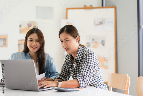 Construction design concept, Two architects is discussing about project and house plan on laptop
