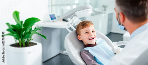 A child sitting in a dental clinic chair smiles at a dentist before undergoing a oral inspection
