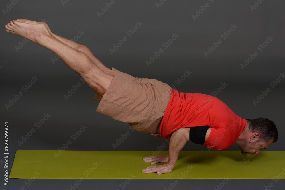 Naklejka premium Man doing yoga in photo studio on isolated background.