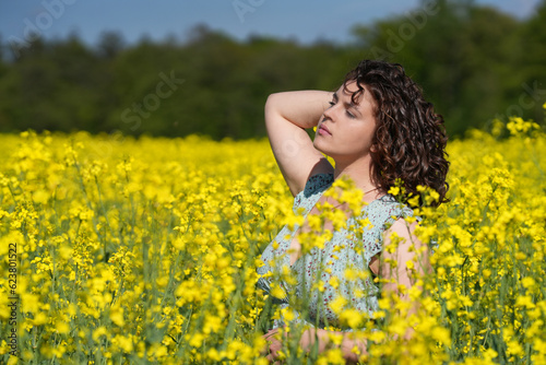 Junge Frau erholt sich in der Sonne mitten in einem blühenden Feld © Markus Kammermann