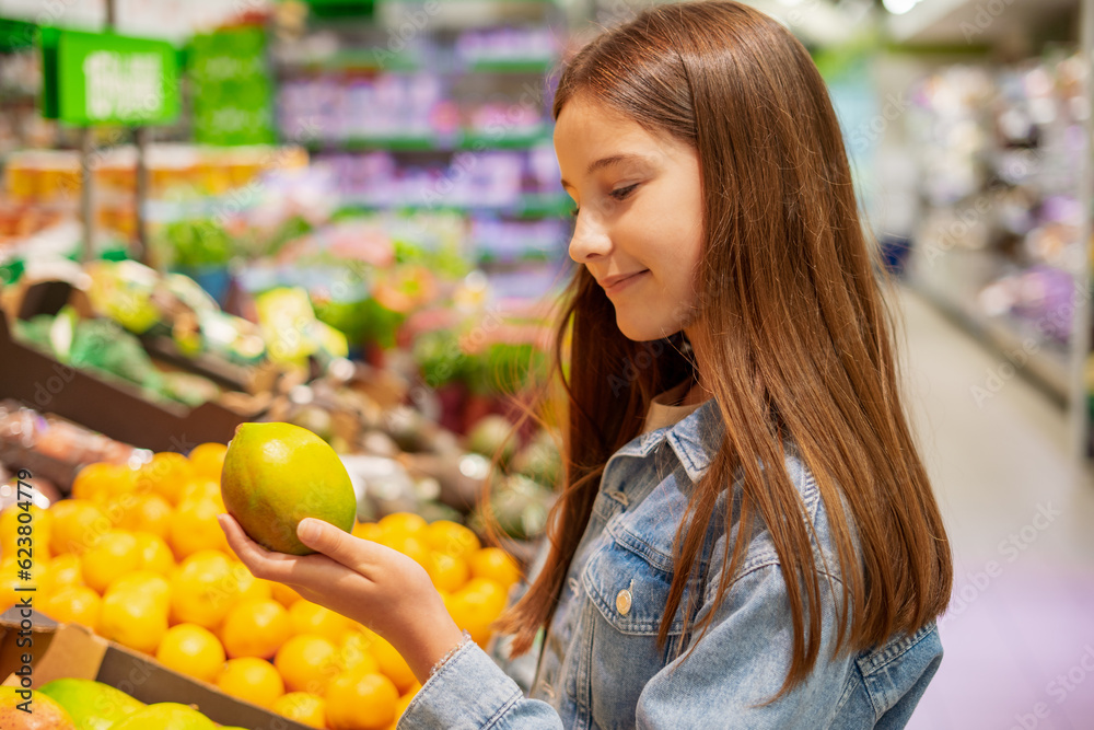 Girl in supermarket chooses fresh fruits and vegetables Girl in supermarket chooses fresh fruits and vegetables