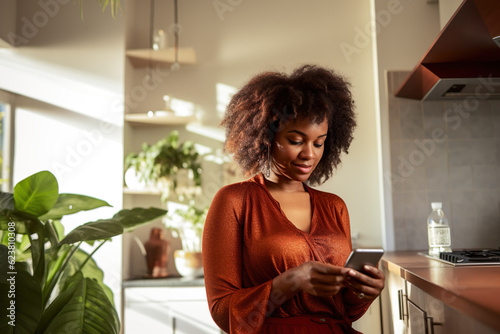an attractive Black woman at home using a mobile phone