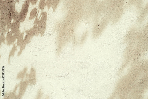 Abstract tree leaves shadows on brown concrete wall texture with roughness and irregularities. Abstract nature concept background. Copy space for text overlay