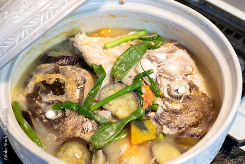 Fish head stew in a ceramic pot. Sinabawang ulo ng isda. 