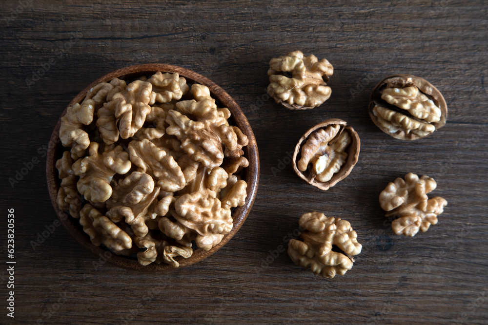 Peeled walnuts and whole walnuts in wooden bowl,top view
Peeled walnuts and whole walnuts in wooden bowl,top view