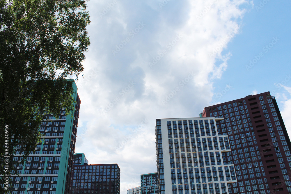 modern buildings in the city of Kyiv, Ukraine with green trees on a blue sky background. clouds over the city. modern buildings in the city of Kyiv, Ukraine with green trees on a blue sky background. clouds over the city.