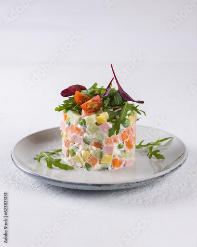 Canvas Print New Year. Olivier salad on a plate with tomatoes and arugula.