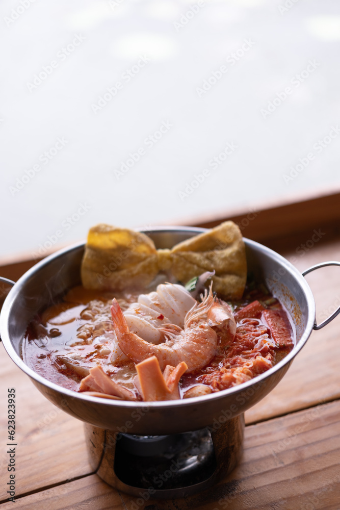 Seafood Tom Yum, hot and sour Thai soup with squid, shrimp served in hot pot Seafood Tom Yum, hot and sour Thai soup with squid, shrimp served in hot pot