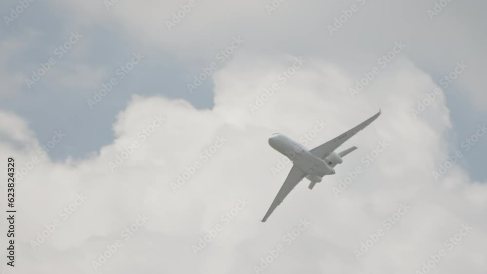 Large white private business Jet during flight under blue sky with clouds Large white private business Jet during flight under blue sky with clouds
