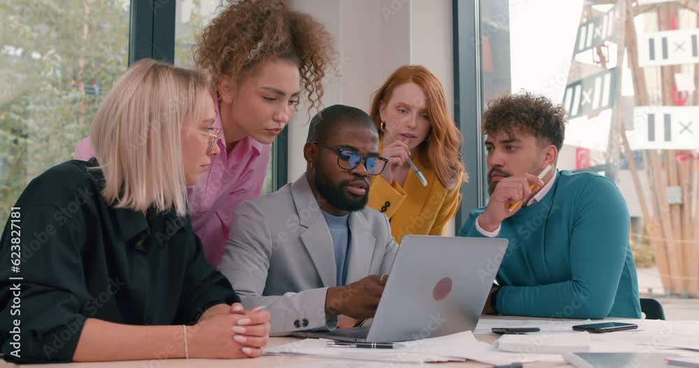 happy diverse mixed-race office workers sit at table in front of laptop, looking at the screen , working together, laughing, having fun, smiling, Slow motion happy diverse mixed-race office workers sit at table in front of laptop, looking at the screen , working together, laughing, having fun, smiling, Slow motion