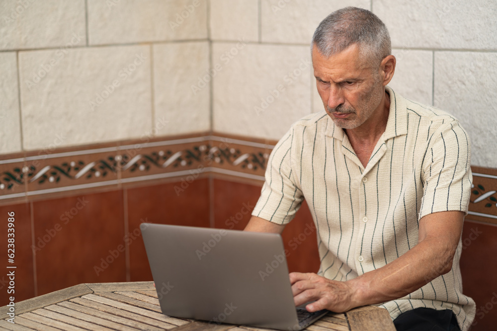 Elder man with white hair concentrate using a laptop Elder man with white hair concentrate using a laptop