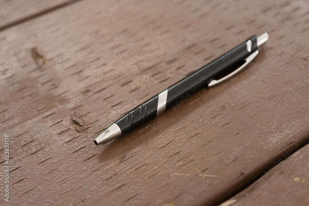 Fototapeta premium ball point pen on a brown wooden table