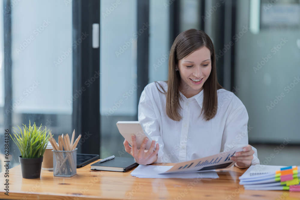 Portrait of beautiful smiling young brunette businesswoman sitting at in the office modern work station