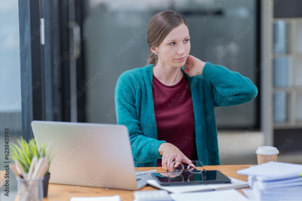 Attractive young office worker holding a binder as she looks at the camera with a sweet friendly smile Attractive young office worker holding a binder as she looks at the camera with a sweet friendly smile