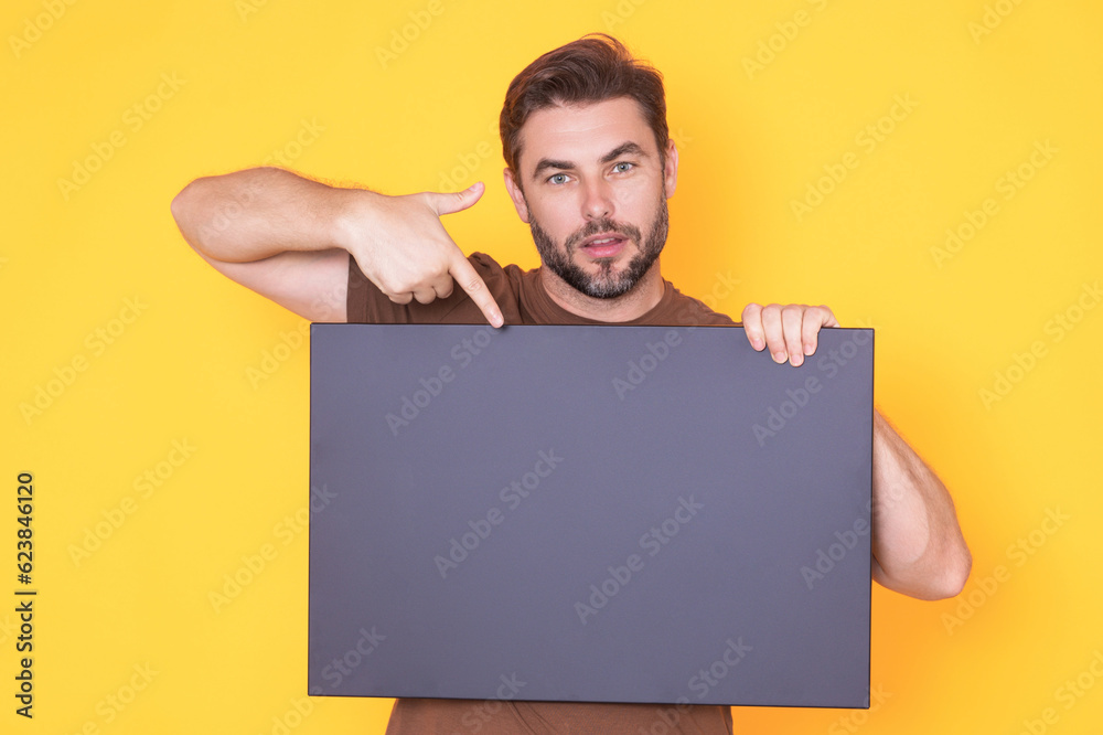 Middle aged man with blank placard. Demonstrating copy space for your text or design. Man showing empty advertisement board on studio background. Blank placard, signboard for ad. Middle aged man with blank placard. Demonstrating copy space for your text or design. Man showing empty advertisement board on studio background. Blank placard, signboard for ad.