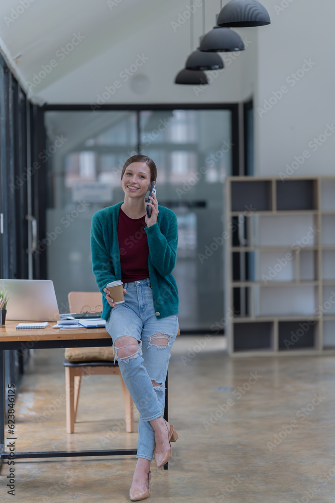 Attractive young office worker holding a binder as she looks at the camera with a sweet friendly smile Attractive young office worker holding a binder as she looks at the camera with a sweet friendly smile