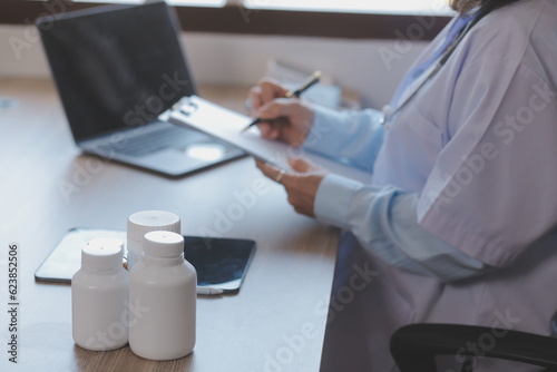 Close-up of stethoscope and paper on background of doctor and patient hands photo