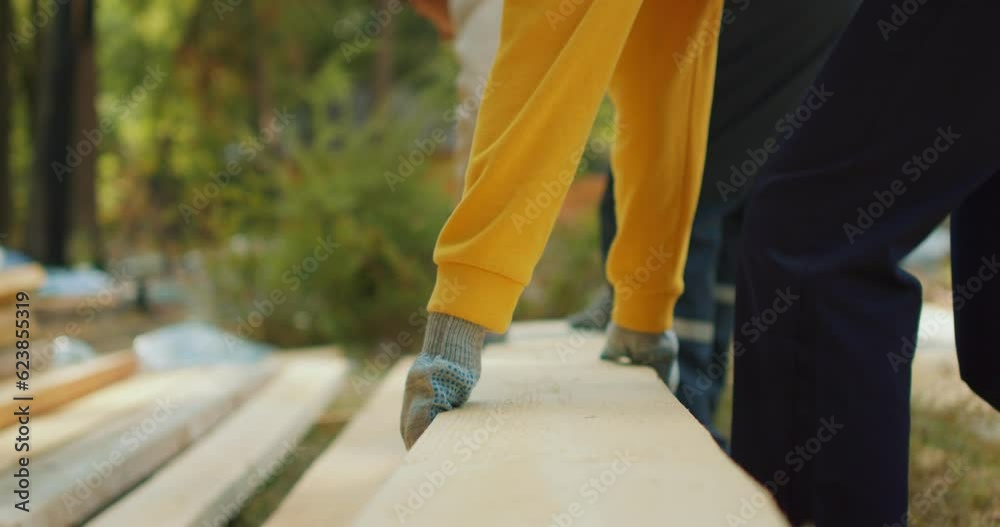 Male and female carpenters carrying piece of wood on at wood processing plants. Confident woodworkers working at work Slow motion soft focus Male and female carpenters carrying piece of wood on at wood processing plants. Confident woodworkers working at work Slow motion soft focus