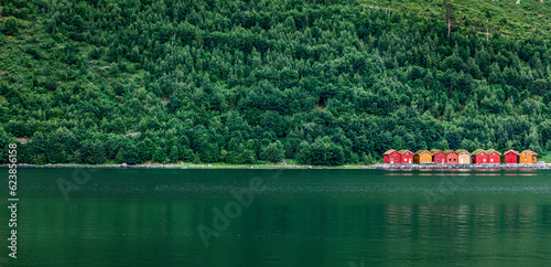 Rote Bootshäuser an einem grünen See in Skandinavien