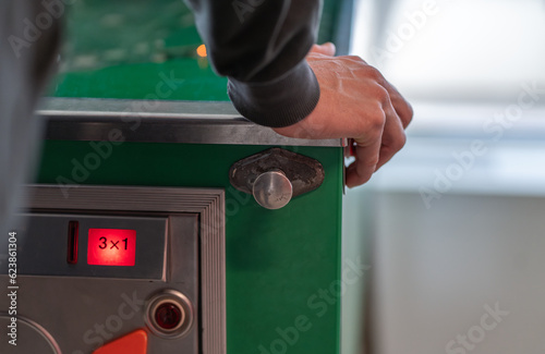 Adult male play pinball game. Vintage old green pinball table machine. Young man pushing buttons on pinball.