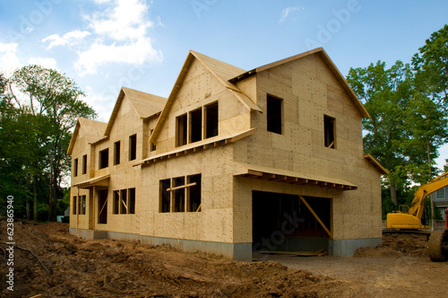 Large suburban house under construction in the sheathing phase.