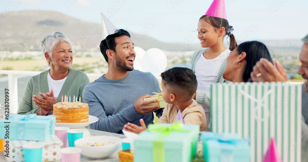 Happy, celebrate and big family at an outdoor birthday party with a dessert cake and presents. Happiness, smile and people clapping hands in celebration for a young man at event outside their home. Happy, celebrate and big family at an outdoor birthday party with a dessert cake and presents. Happiness, smile and people clapping hands in celebration for a young man at event outside their home.