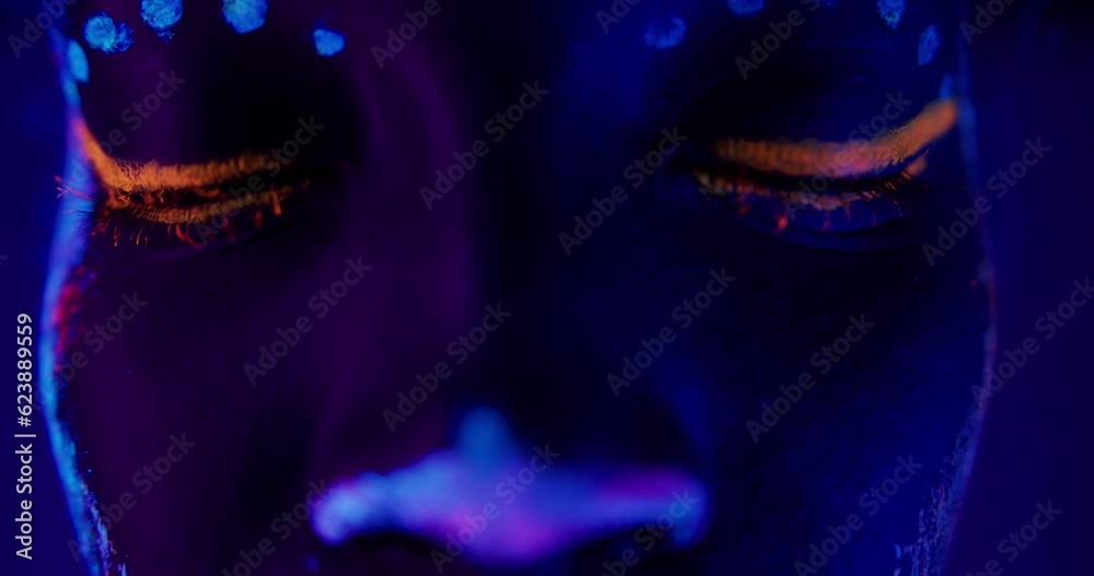 modern fantastic african model face with closed eyes posing to camera, opening eyes fluorescent prints on skin, glowing on ultra violet lights. interesting colorful face