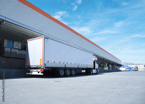 white truck in front of the warehouse, a loading truck