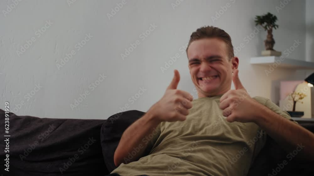 The guy looks into the camera and gives a thumbs up, expressing his approval, positive opinion, or agreement. Concept Approval, Positivity, Support. The guy looks into the camera and gives a thumbs up, expressing his approval, positive opinion, or agreement. Concept Approval, Positivity, Support.