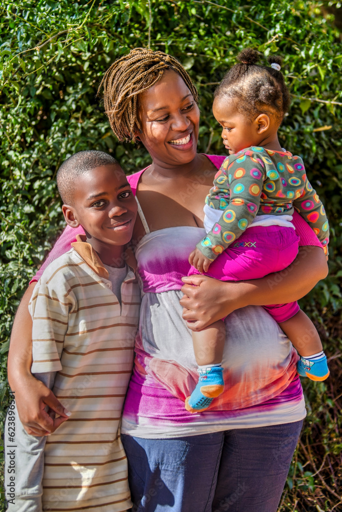 Fototapeta premium African family with single mother hugging and holding her two kids