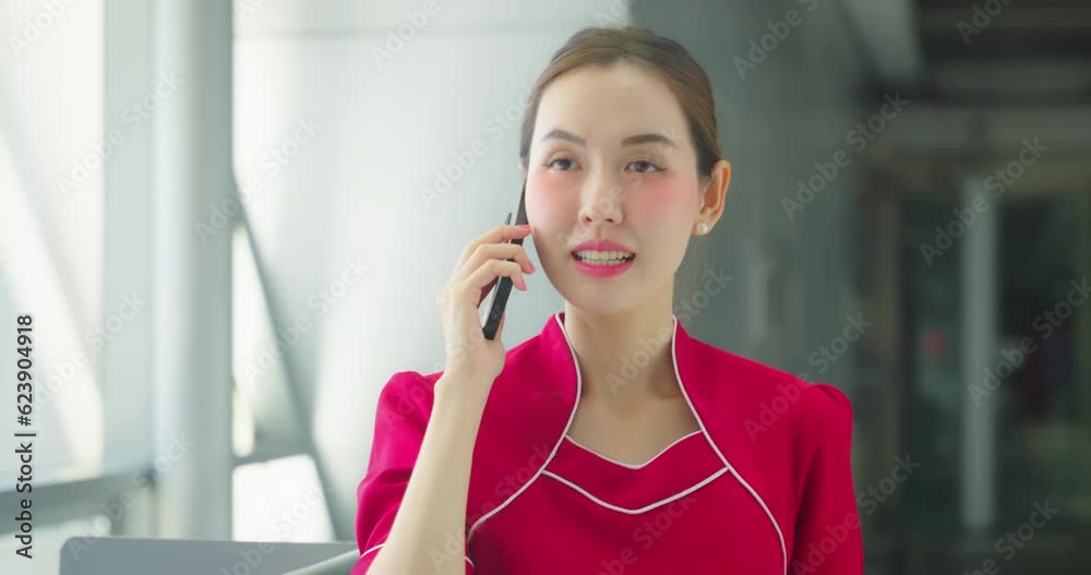 Beautiful flight attendant uses the phone to talk with friends or family in the airport. Beautiful flight attendant uses the phone to talk with friends or family in the airport.