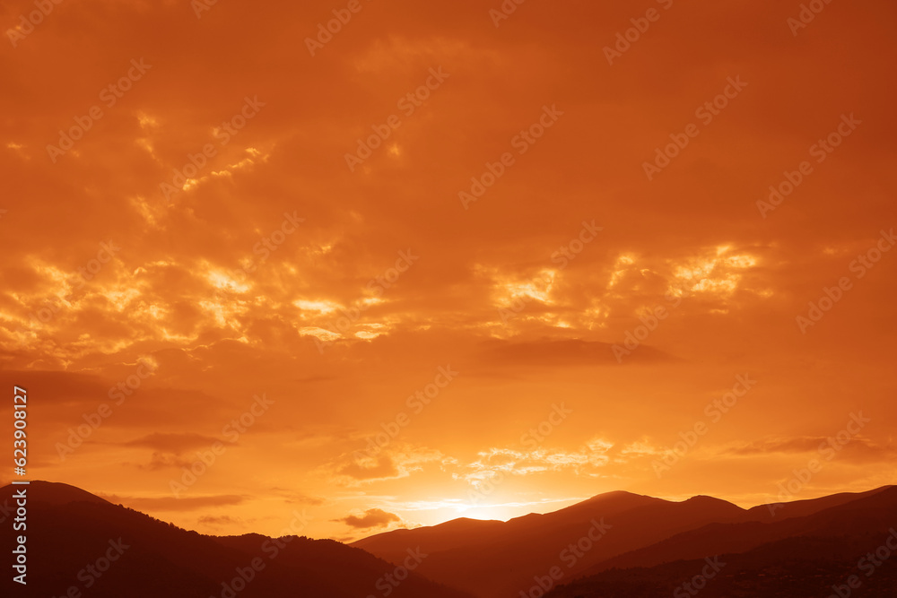 A bright colorful sunset sky over the black silhouettes of the mountains. Dark sunset sky with bright colors over a mountain. Scenic View Of Silhouette Mountains Against Sky During Sunset