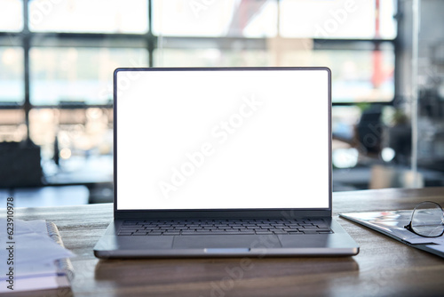 Laptop pc mock up template design on office workplace desk, white mockup empty blank computer screen on office work table business web technology at modern workspace, closeup.