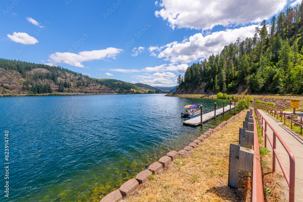 A small boat docks at the Mineral Ridge public boat launch at Wolf Lodge Bay on Lake Coeur d'Alene at summer, in the mountains of Coeur d'Alene, Idaho USA. A small boat docks at the Mineral Ridge public boat launch at Wolf Lodge Bay on Lake Coeur d'Alene at summer, in the mountains of Coeur d'Alene, Idaho USA.