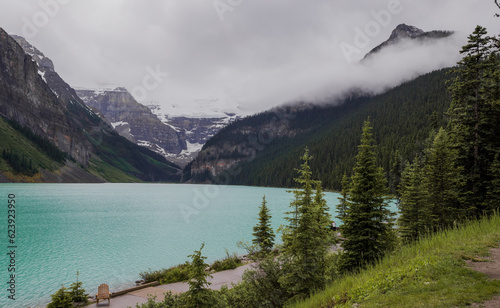 Amazing Lake Louise in Banff National Park, Alberta, Canada. Cloudy day after rain. Blue lake water and misty mountins. Famous place for traveling. Idyllic summer landscape.