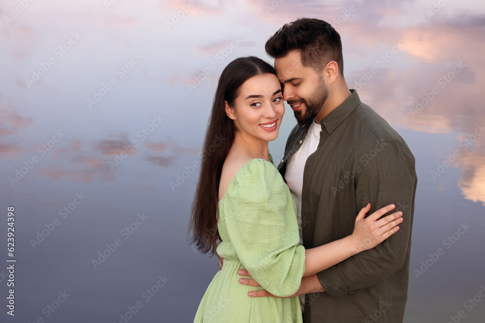 Romantic date. Beautiful couple spending time together near lake, space for text Romantic date. Beautiful couple spending time together near lake, space for text