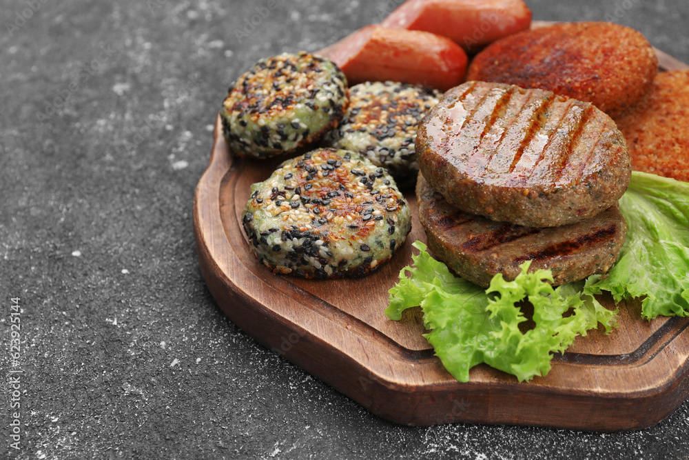 Different tasty vegan meat products and lettuce on grey table, closeup. Space for text Different tasty vegan meat products and lettuce on grey table, closeup. Space for text