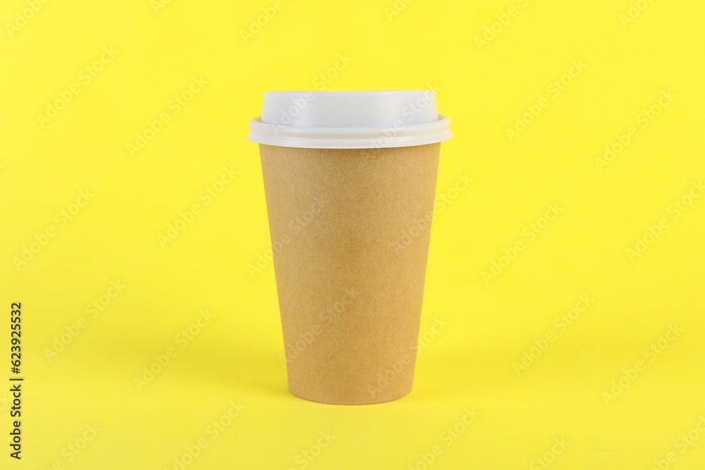 Paper cup with plastic lid on yellow background. Coffee to go Paper cup with plastic lid on yellow background. Coffee to go