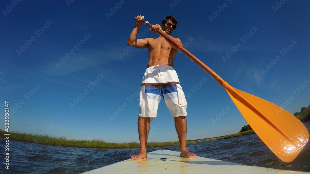 Obraz premium Man stand up paddleboarding