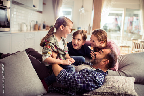 Young family having fun on the couch in the living room