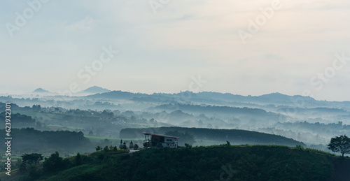 House on hill. Mountain farm house with foggy valley and distant mountains on horizon. Wonderful nature scenery of thailand. photo