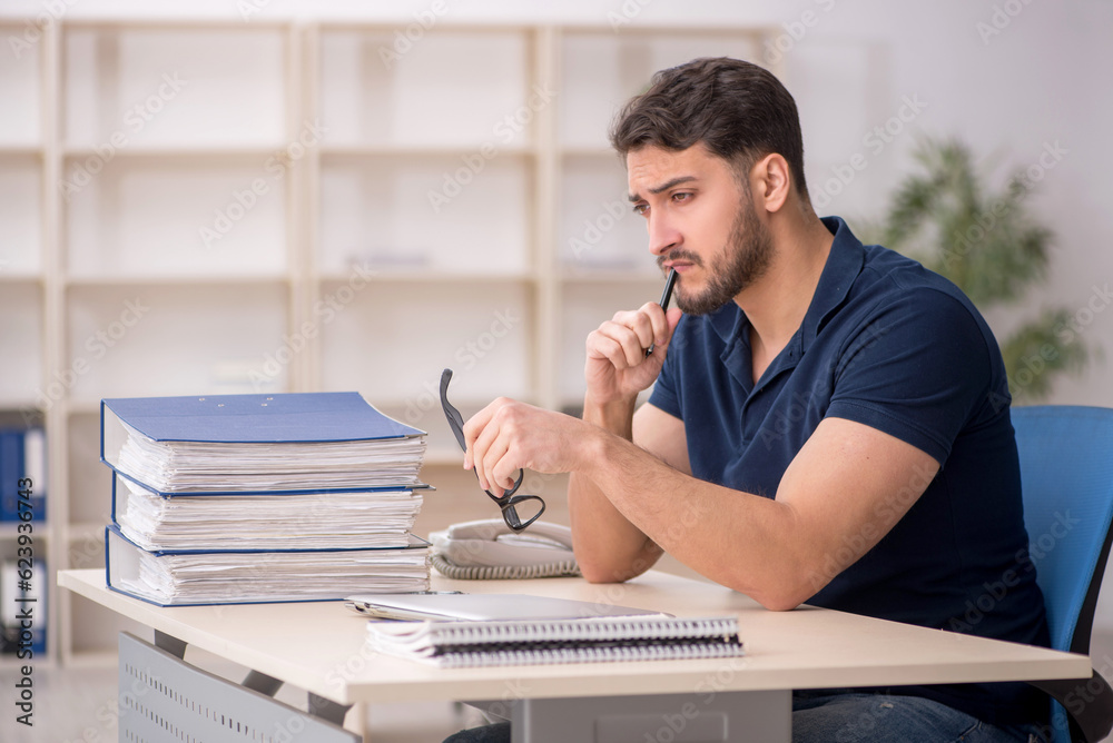 Obraz premium Young male employee sitting at workplace