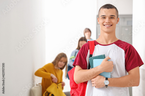 Teenage boy with books at school © Pixel-Shot