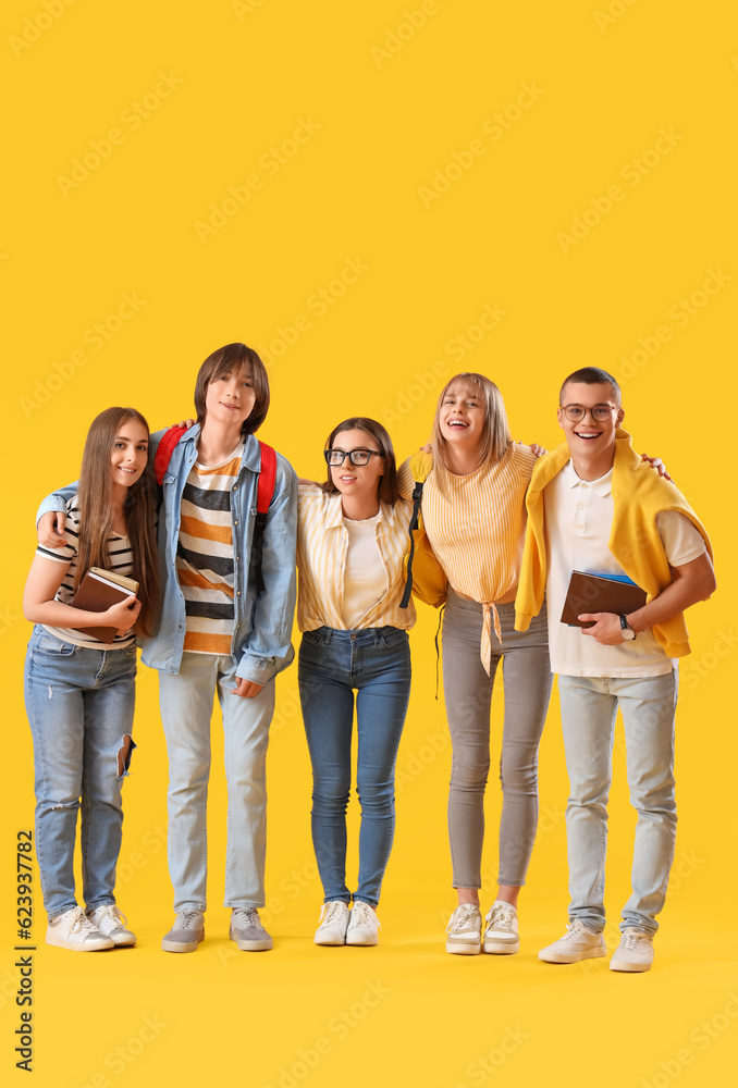 Fototapeta premium Group of teenage students on yellow background