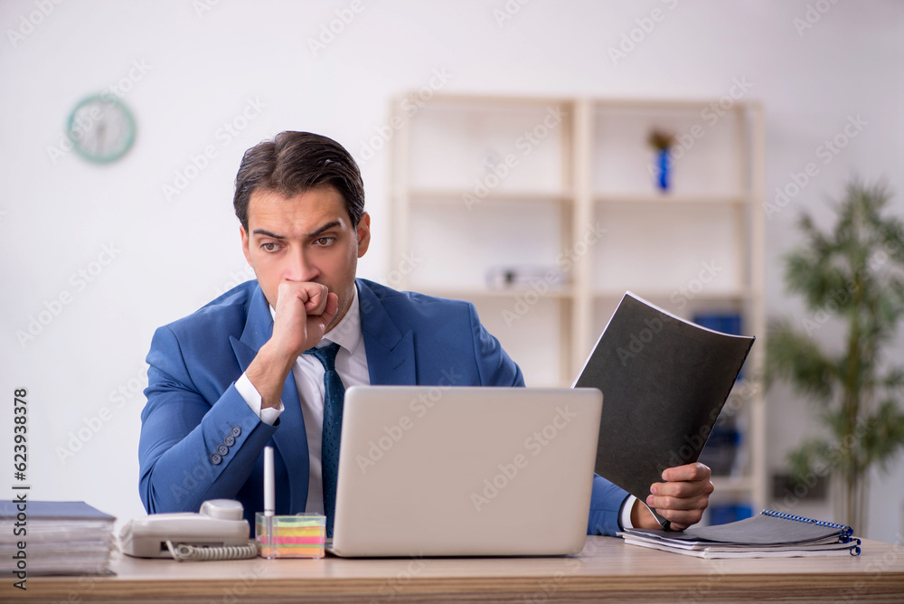 Young male employee working in the office Young male employee working in the office