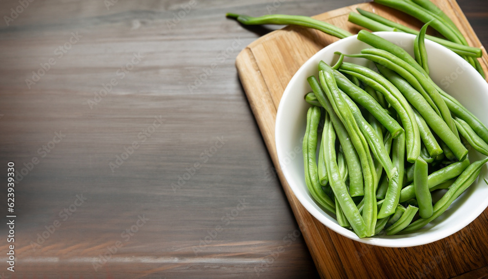 Green beans in white bowl on cutting board. Green beans in white bowl on cutting board.