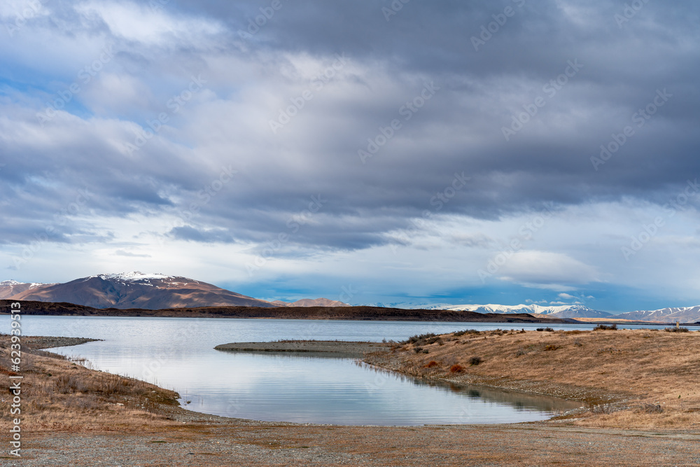 Scenic sunrise view of Lake Pukaki, with their mesmerizing turquoise hue and reflect the majestic snow-capped Southern Alps. Perfect for travel brochures, nature magazines, and inspirational content.