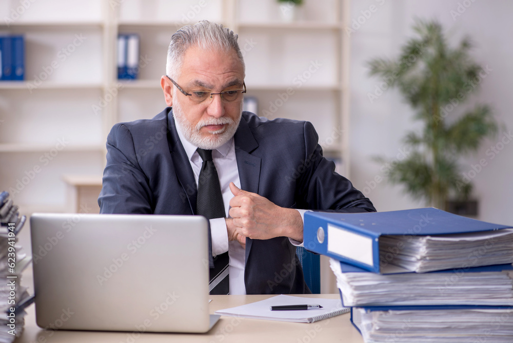 Old male employee and too much work at workplace Old male employee and too much work at workplace