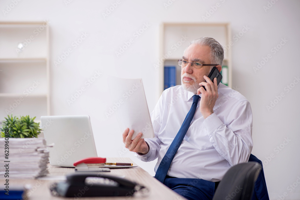Old male employee working in the office Old male employee working in the office