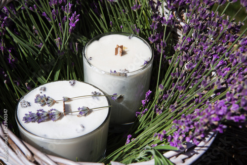 Aromatized candles and a bouquet of lavender are in a wicker basket.